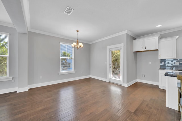 kitchen featuring a notable chandelier, tasteful backsplash, white cabinetry, dark hardwood / wood-style flooring, and crown molding