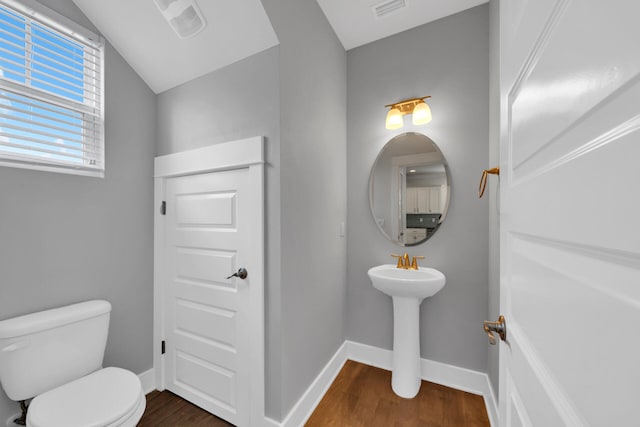 bathroom featuring vaulted ceiling, hardwood / wood-style flooring, and toilet