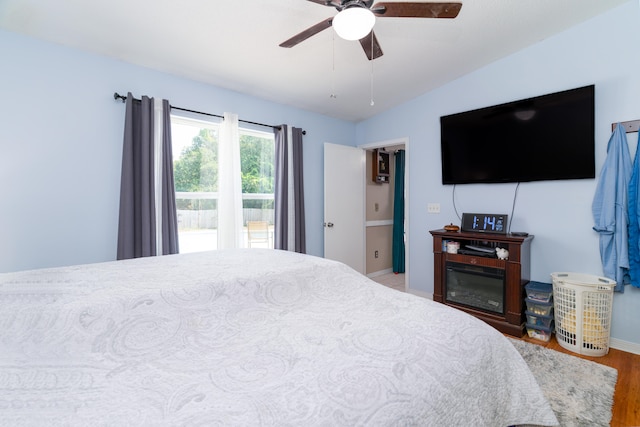 bedroom featuring hardwood / wood-style floors, vaulted ceiling, and ceiling fan