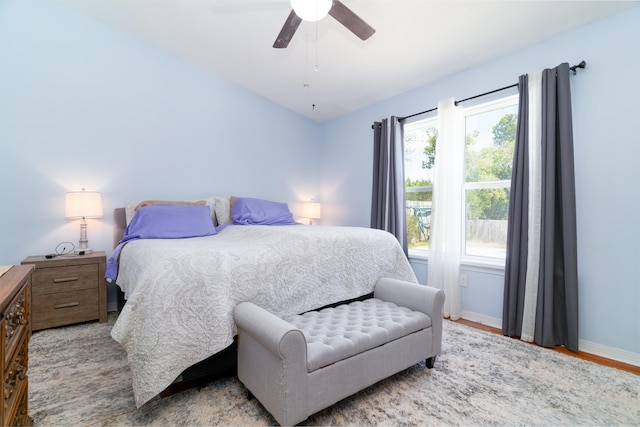 bedroom featuring ceiling fan, light hardwood / wood-style floors, and multiple windows