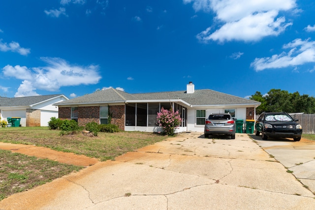 ranch-style home featuring a front yard and a sunroom