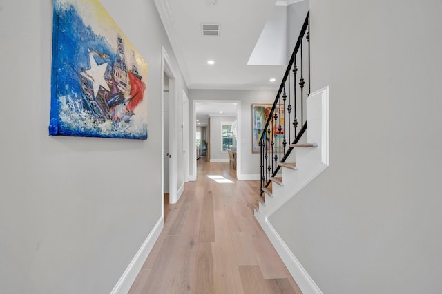 corridor featuring ornamental molding and light wood-type flooring