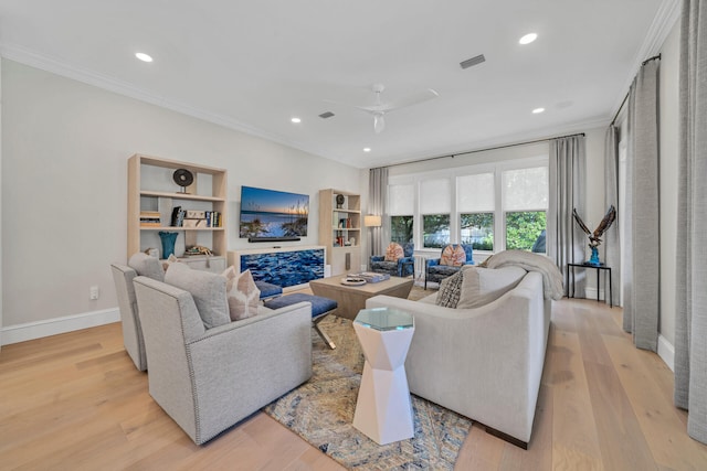 living room with light hardwood / wood-style flooring, ceiling fan, built in shelves, and ornamental molding