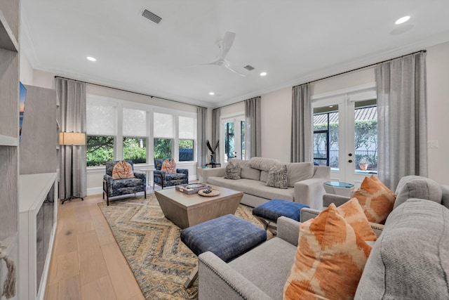 living room with a wealth of natural light, ceiling fan, light hardwood / wood-style floors, and french doors