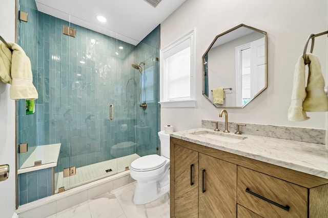 bathroom with tile floors, vanity, an enclosed shower, and toilet