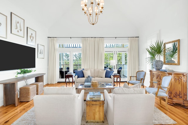 living room featuring light hardwood / wood-style floors, a chandelier, french doors, and plenty of natural light