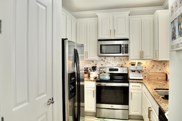 kitchen with stainless steel appliances, white cabinetry, and light stone counters