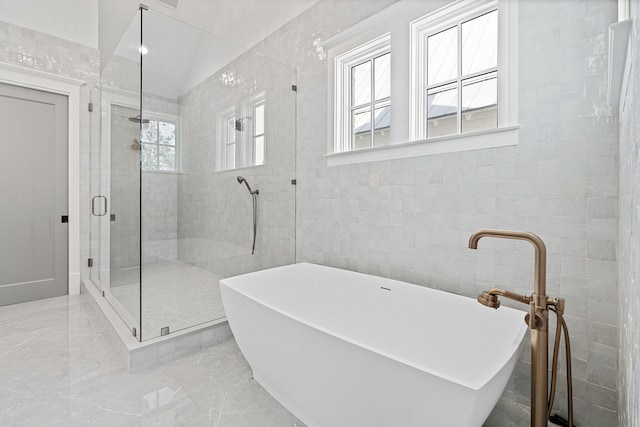 bathroom featuring separate shower and tub and tile walls