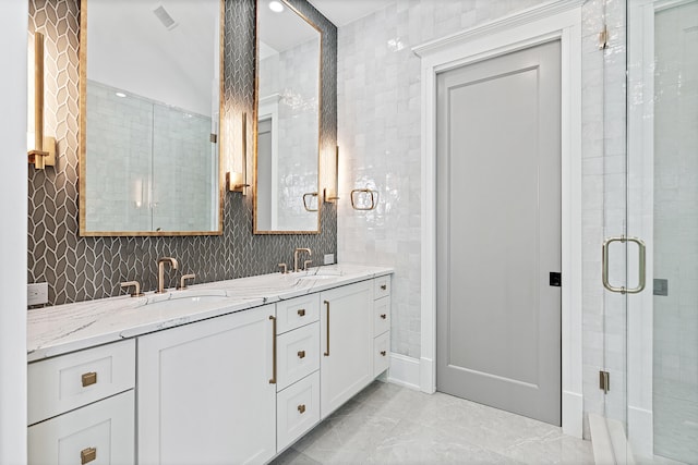 bathroom with dual vanity, walk in shower, tile patterned flooring, and tile walls