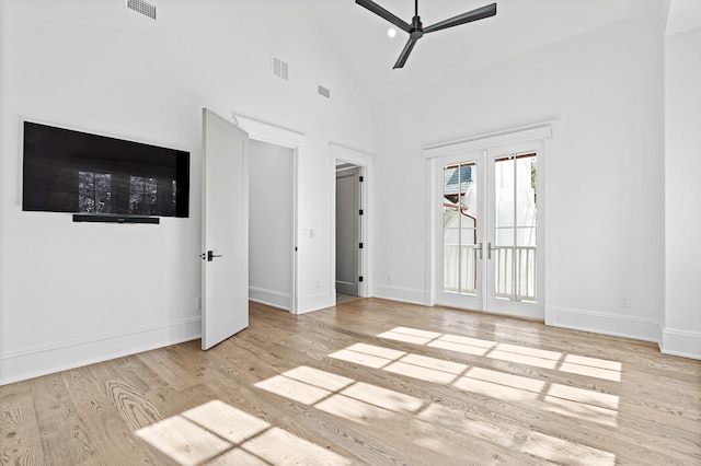 unfurnished room with high vaulted ceiling, light hardwood / wood-style floors, french doors, and ceiling fan