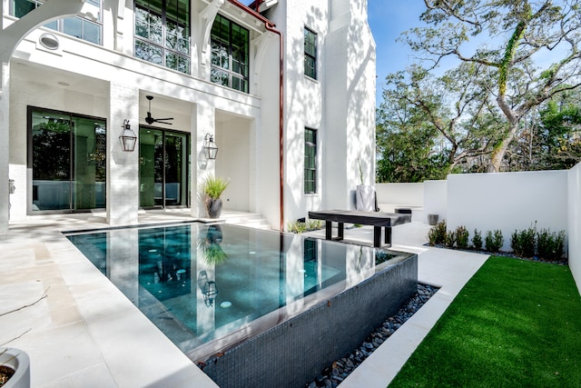 view of swimming pool featuring ceiling fan and a patio