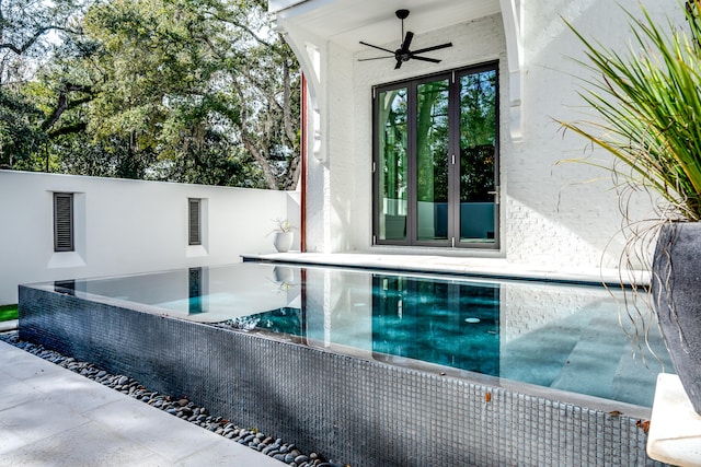 view of swimming pool featuring ceiling fan and a patio area