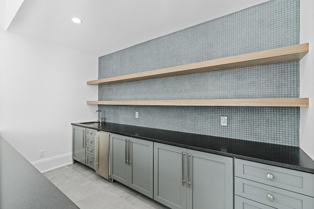 kitchen with light tile patterned flooring, sink, decorative backsplash, and gray cabinetry