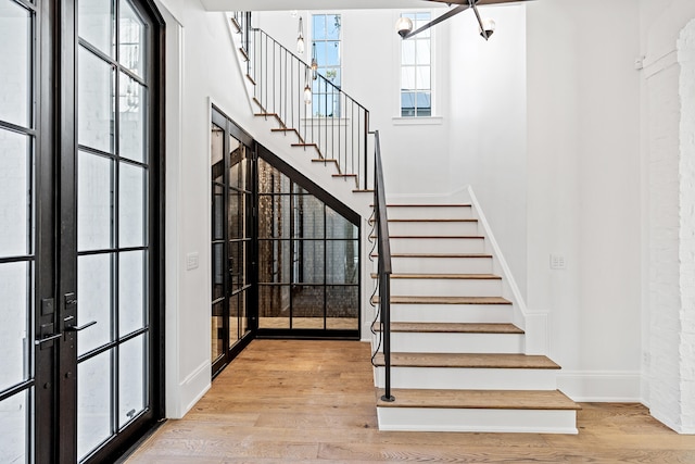 stairs with hardwood / wood-style floors and french doors