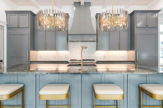 kitchen featuring beam ceiling, dark stone countertops, and custom range hood