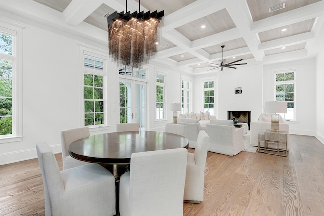 dining area with plenty of natural light, beamed ceiling, light wood-type flooring, and coffered ceiling