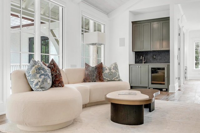 sitting room featuring wine cooler, bar area, and light hardwood / wood-style flooring