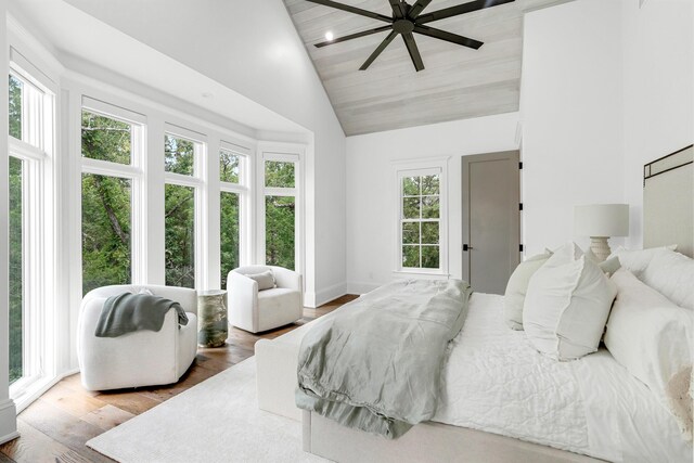 bedroom featuring hardwood / wood-style flooring, multiple windows, and high vaulted ceiling