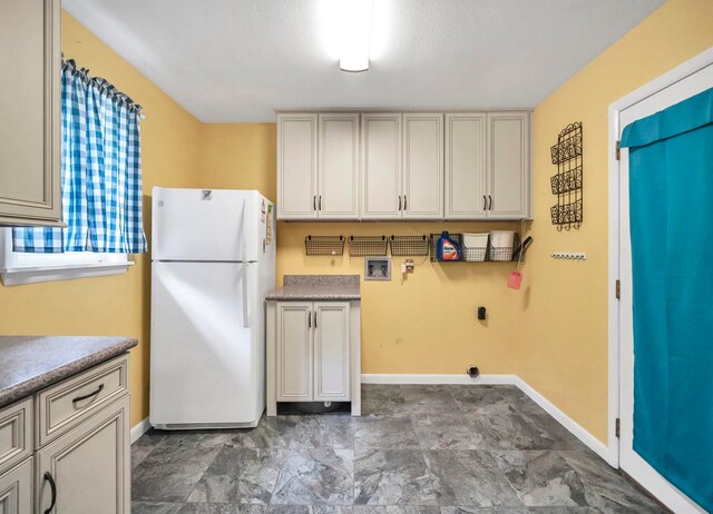 kitchen with white refrigerator and dark tile floors