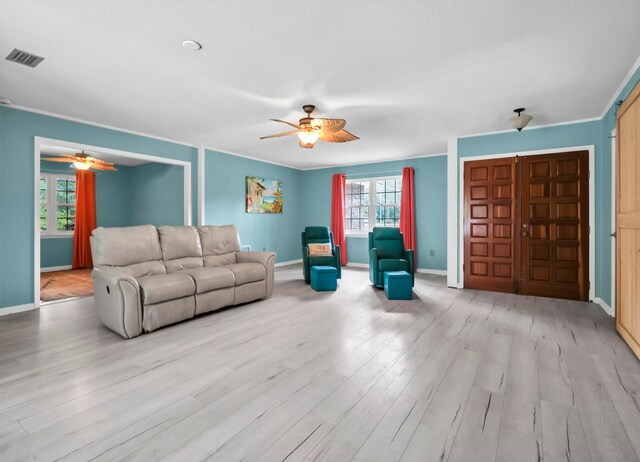 living room featuring light hardwood / wood-style flooring, a wealth of natural light, and ceiling fan