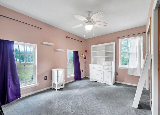 unfurnished bedroom with dark colored carpet and ceiling fan