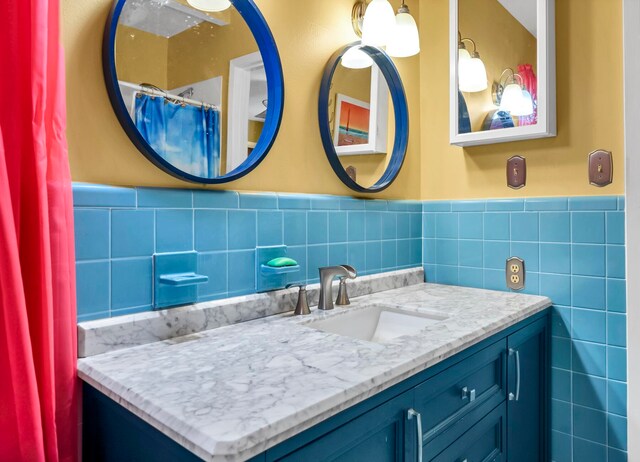 bathroom featuring backsplash, tile walls, and vanity with extensive cabinet space