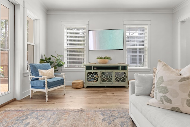 living area with crown molding, baseboards, and wood finished floors