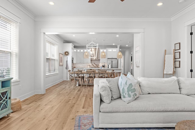 living room with recessed lighting, light wood-type flooring, baseboards, and crown molding