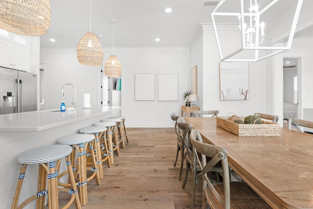 dining area featuring recessed lighting, light wood-style floors, a chandelier, and ornamental molding