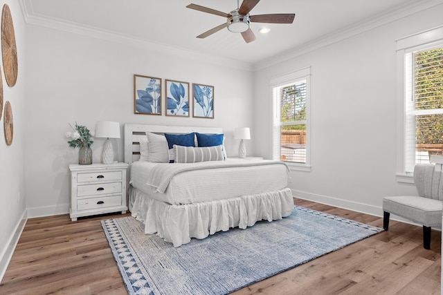 bedroom with multiple windows, wood finished floors, and crown molding