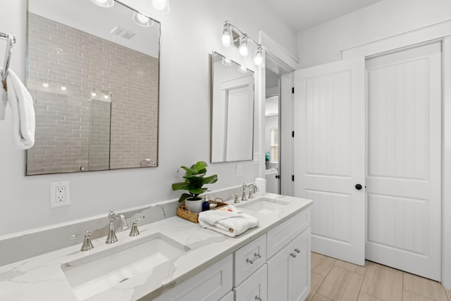 full bath featuring a sink, visible vents, and double vanity