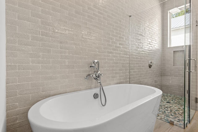 bathroom with a soaking tub and a shower stall