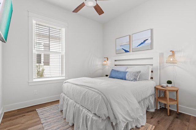 bedroom with ceiling fan, baseboards, and wood finished floors