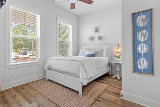 bedroom featuring a ceiling fan, wood finished floors, and baseboards