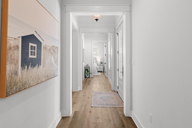 corridor with light wood finished floors and baseboards