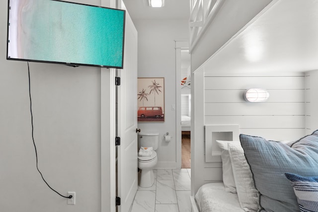 bathroom with baseboards, toilet, marble finish floor, and ensuite bathroom