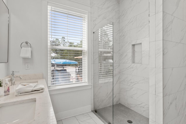 bathroom with plenty of natural light, a shower stall, baseboards, and double vanity