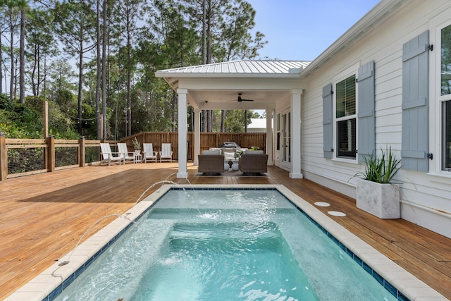 view of swimming pool with a deck, a ceiling fan, a jacuzzi, fence, and an outdoor hangout area