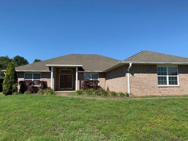 single story home with a front lawn