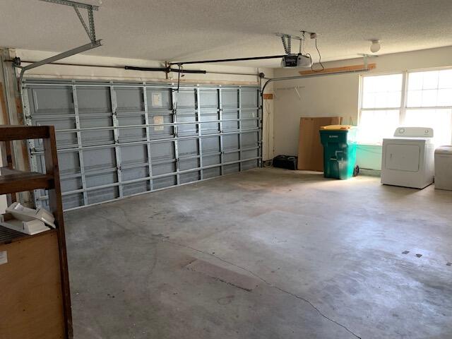 garage with washer / dryer and a garage door opener