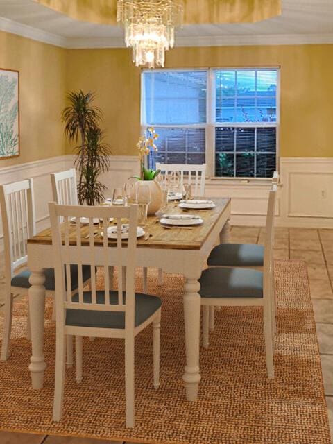 dining area featuring tile patterned flooring, ornamental molding, and a notable chandelier