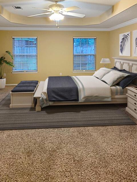 bedroom with ornamental molding, ceiling fan, and a tray ceiling