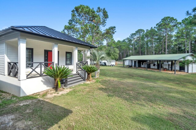 view of yard featuring an outdoor structure and covered porch