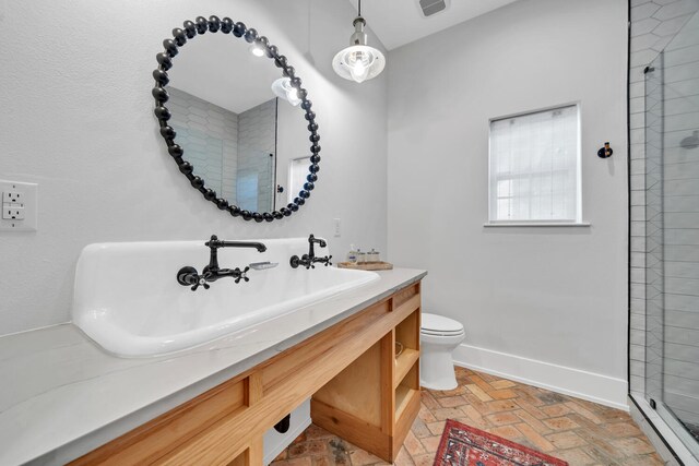 bathroom with walk in shower, vanity, and toilet