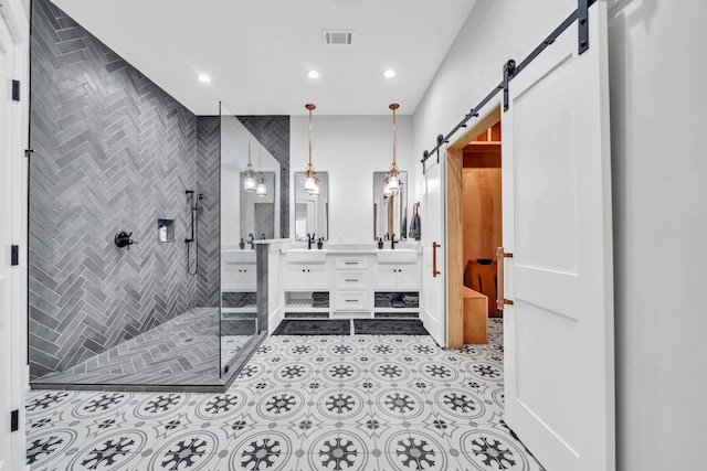 bathroom with a shower with shower door, vanity, and tile flooring