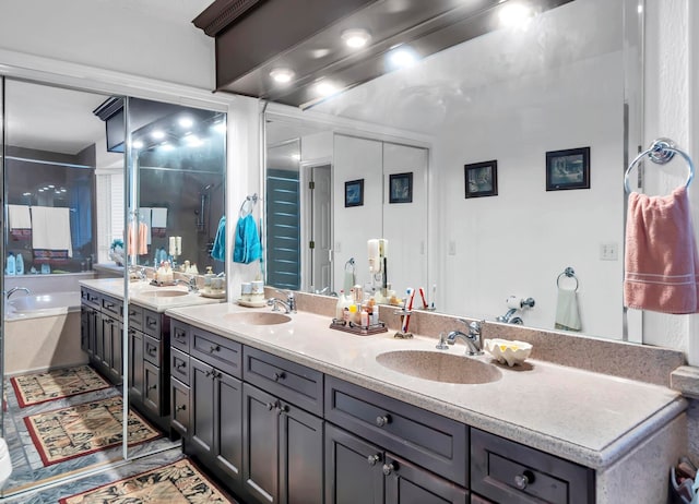 bathroom with dual sinks, independent shower and bath, and vanity with extensive cabinet space