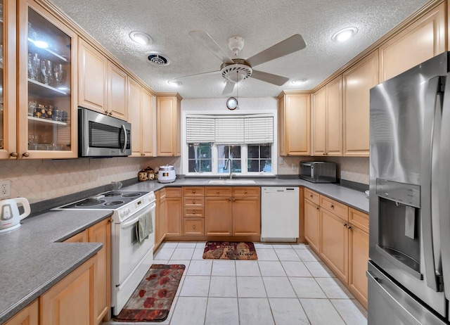 kitchen with ceiling fan, light tile floors, a textured ceiling, sink, and stainless steel appliances