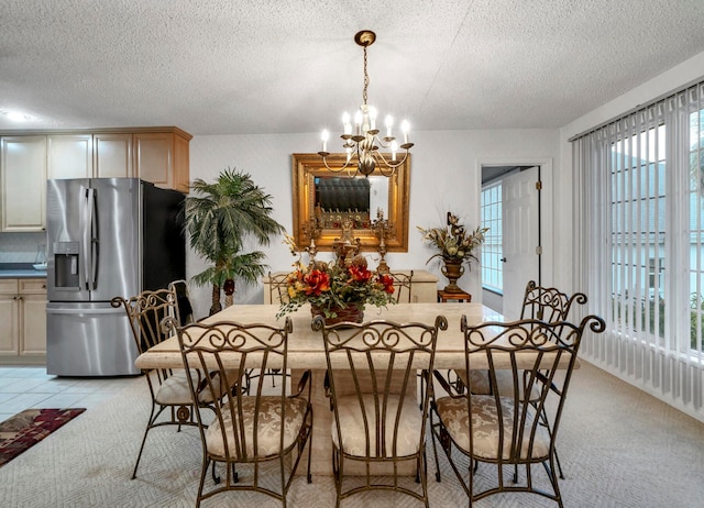 carpeted dining area with a chandelier and a textured ceiling