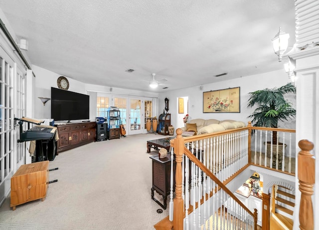 interior space with light colored carpet, a textured ceiling, french doors, and ceiling fan