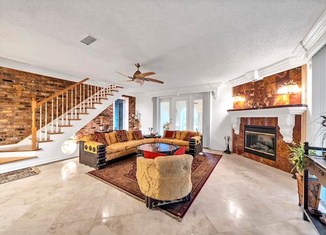 tiled living room with brick wall, ceiling fan, and a textured ceiling